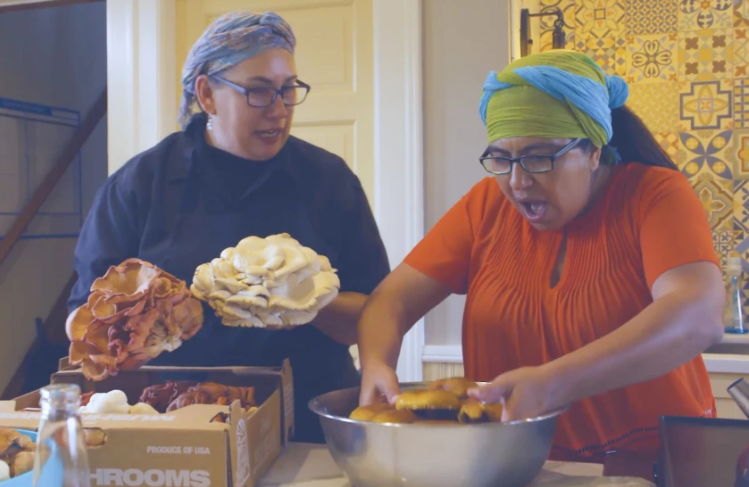 two women in kitchen preparing mushrooms